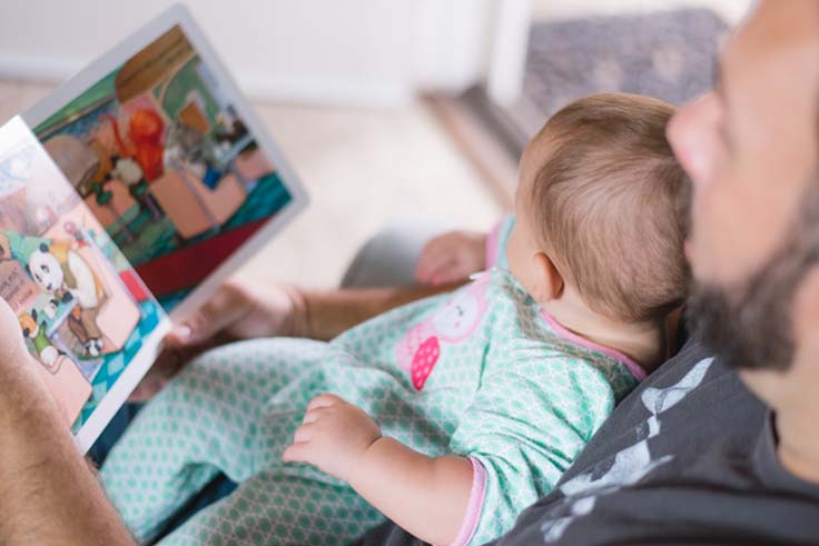 Rodzic czytający książkę i otwierający okno na świat dla niemowlaka